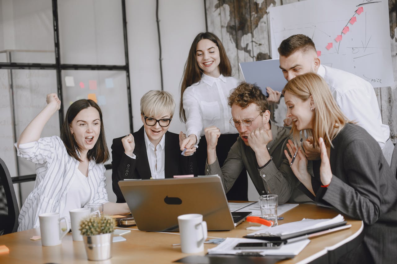 Group of diverse colleagues celebrating success in a modern office